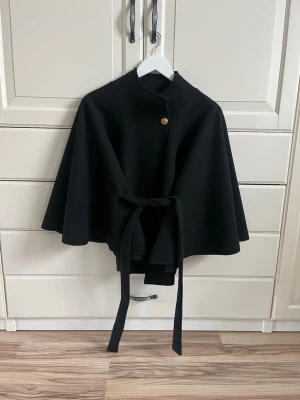 Poncho - Säljer en superfin svart kappa i form av en poncho från missäy. Nyskick, aldrig använd. Oneszie🩷