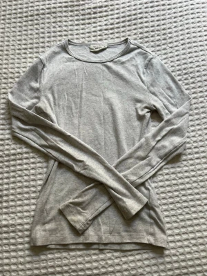 Ljusgrå långärmad topp Gina Tricot - En basic ljusgrå långärmad topp från Gina Tricot. Aldrig kommit till användning.