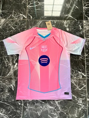 Rosa FC Barcelona matchtröja Nike - Snygg rosa FC Barcelona matchtröja från Nike med gradient i vitt och blått. Tröjan har klubbmärke, Nike-logga och Spotify som sponsor på bröstet. Tillverkad i lätt och ventilerande funktionsmaterial, perfekt för fotboll eller träning.