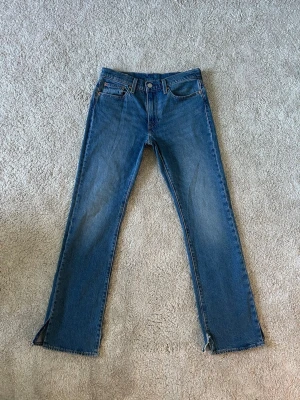 Blåa Levis 527 Bootcut Jeans Storlek W29 L32 - Mycket fina Levis jeans i blå färg | Jeansen är i mycket bra skick och sparsamt använda. |  Äkta som allt annat jag säljer! ✅ |  Storlek: W29 | Skick: Mycket Bra Skick - har blivit klippta på sidan av benen så de sitter bättre på skor | Färg: Blå | Märke: Levis Modell: Jeans |   Hör gärna av dig vid frågor så svarar jag så fort jag kan! 😁 |  (SKU - 186)