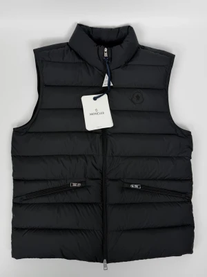 Moncler Letchel väst helt ny svart (L) - Helt ny med lappar nypris 9.700kr vårt pris 5490kr storlek 3 motsvarande L. Nyaste kollektionen. Finns att köpa på våran hemsida tillsammans med hundratals andra varor, Fashionels.com