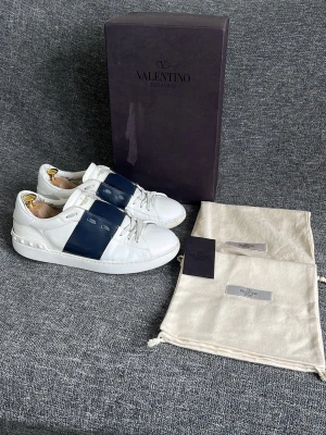 Valentino Open navy - Hej, Valentino Garavani skor. Tillfredsställande skick. Skorna är slitna inuti och på sulan men annars i helhet fint skick. Skorna har vårdats av skomakare både på ovansidan men också midsulan. Skolåda, 2 dustbags och kort medföljer till skorna! Skorna är äkta och har ett nyvärde på 7200kr. Hör av dig! 