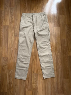 Äkta Polo Ralph Lauren chinobyxor i storlek 20 – Mycket fint skick. - Äkta Polo Ralph Lauren chinobyxor i storlek 20 (junior, passar ca XS/S, ca 170-174 cm). Mycket fint skick! Klassisk beige färg med bekväm elastisk stretchmidja, sidofickor samt bakfickor. Garanterat 100 % äkta original (verifieringslänk/QR-kod sitter på insidan av lappen). Passar perfekt till både vardag och finare tillfällen. Skicka gärna ett meddelande om du har några frågor – jag svarar snabbt!