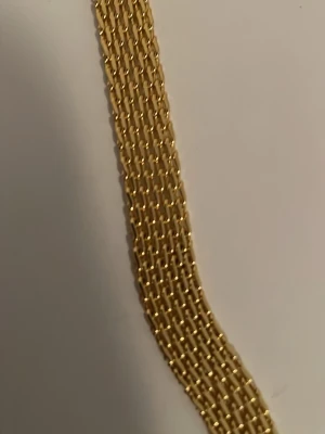 guldpläterat armband i 18k - Snyggt och brett armband i 18 k guldpläterat  med flera rader av tätt sammanlänkade kedjor. Armbandet har en rund bricka med 18K-stämpel och ett robust klolås. Perfekt för dig som gillar statement-smycken i klassisk guldfärg.