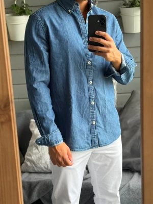  Denimskjorta - Säljer denna blåa denimskjorta från Dressman i storlek M då den är lite för stor på mig. Passar underbart nu till sommaren! Skjortan har inga defekter alls! Bara att skriva vid funderingar!🌟