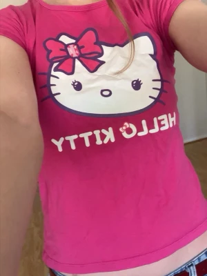 Hello Kitty baby tee - Trycket har sprickor på rosetten och morrhåren. Färgen är mer som på första bilderna 💕 Kontakta mig innan köp!! 