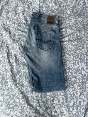 Blå slim fit jeans från Blend - Snygga blå slim fit jeans från Blend med klassisk femficksmodell och slitningar på låren. Jeansen har dragkedjegylf och detaljerade sömmar på bakfickorna. Tillverkade i mjuk denim med lätt tvättad look.