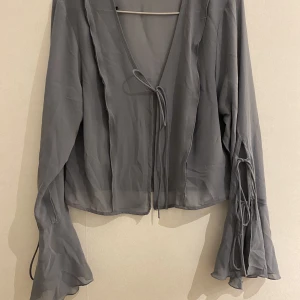 Topp i mesh - Skitsnygg mesh topp i en grå färg med fina sydda detaljer. Storlek M men passar S-L. Köpt på zalando, ordinarie pris 349kr. Frakt tillkommer , bilder ifrån förra säljaren, ej några defekter/ ändringar skriv för