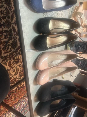 Mix av pumps i olika färger - Säljer flera par klassiska pumps i svart, marinblått och ljusrosa. Skorna har rundad tå och klack, vissa i mockaimitation och andra i lack. Perfekta för dig som vill ha stilrena och enkla klackar till garderoben.