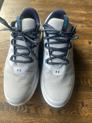 Golfskor Under Armour sneakers 43 - Snygga och lätta Golfskor från Under Armour med marinblå detaljer och matchande skosnören. 