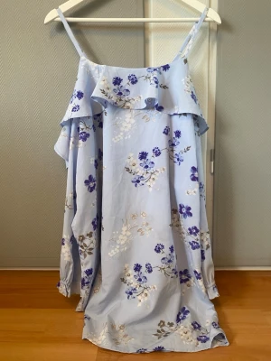 Blommig klänning  - Säljer en blå och lila blommig klänning från Gina Tricot. 