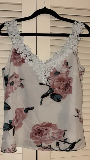 Ljust blommigt linne | Storlek S - 💕 30% bundlerabatt vid köp av minst två artiklar.                                                                       🌸 Ljust linne med virkade detaljer i v-ringningen. Ljus bas med ett vackert blommönster i toner av rosa, dusty rose och grönt.                                                               ✔️Märke: Shein                                                        📏 Storlek S.                               ⭐️ Fint använt skick. Hel och ren utan fläckar, hål eller andra synliga brister.