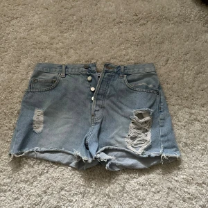 Ljusblå jeansshorts med slitningar - Säljer ett par ljusblå jeansshorts som passar perfekt nu när det börjar bli varmare. Aldrig använt så jättebra skick! Pris kan diskuteras 