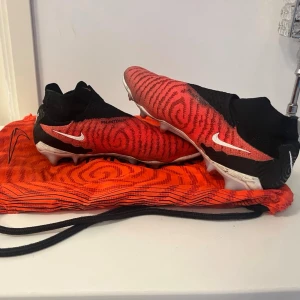 Nike phantom fotbollskor  - Tjena! Säljer ett par riktigt feta fotbollsskor som egentligen är ganska dyra, men jag säljer dem till ett bra pris.  Anledningen till att jag säljer dem är att de är för små för mig. De är i storlek 40, men jag rekommenderar dem främst till dig som har storlek 38–39, då de passar bäst där.  Om du har storlek 40 kan de funka, men de kan vara lite svåra att få på. Har du storlek 41 eller större så kommer de troligtvis vara för små.  För mig var de väldigt trånga och jag kunde knappt spela i dem, 