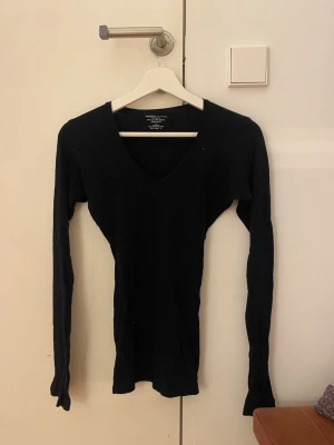 Svart långärmad topp Majestic Filatures - Säljer en svart långärmad topp från Majestic Filatures Paris (Sellpy). Toppen har en djup v-ringning och är tillverkad i en mjuk mix av 70% bomull och 30% kashmir. Passformen är slim. Har sytt in den! Ser konstig ut på en galje fast är jätte fin på. Står ingen storlek fast skulle gissa på S-XS🩷 