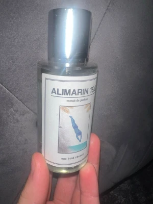 ALIMARIN 45-47ml kvar extrait de parfum - Fräsch parfym från one bold chemist, ALIMARIN 15ml extrait de parfum. Flaskan är genomskinlig med silverfärgat lock och modern etikett med blå illustration. Perfekt för dig som gillar unika dofter i stilren förpackning. 45-47ml kvar av den. Den är 50ml 