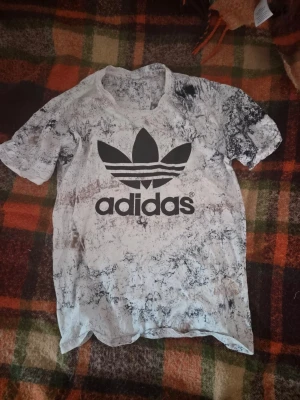 Adidas t-shirt med marmormönster - Säljer en vit och svart/vit/brun Adidas t-shirt med stort tryck av Adidas logga på bröstet. Det är storlek M