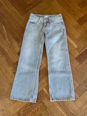Ljusblåa raka jeans med fickor - Säljer ett par gråa baggy jeans från Gina Tricot i storlek 140.