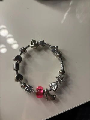 Silverarmband med charms💕 - Snyggt silverfärgat armband med flera olika berlocker som hjärtan, stjärna, snöflinga och en rosa pärla. Man kan köpa till berlocker och blanda som man vill🩷🩷Armbandet har en mix av blanka och mönstrade detaljer som ger en cool och personlig look. Perfekt för dig som gillar att sticka ut med accessoarer.