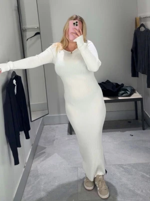 Vit ribbad bodycon långklänning med båtringning  - Säljer en vit, ribbad bodycon långklänning med båtringning, lång ärm och figurnära passform. Klänningen är använd 1 gång då jag ändrade storlek. Inköpt för 349kr.