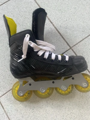 Bauer inlines svart och gul - Säljer ett par Bauer inlines i svart med gula detaljer och vita skosnören. Skalet är gjort i hårdplast och har fyra gula hjul på varje sko. Perfekt för dig som gillar att åka snabbt och smidigt på asfalt.