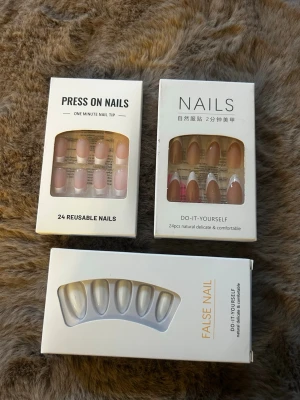 Tre förpackningar press-on naglar - Säljer tre olika förpackningar press-on naglar i nude, rosa och transparent. Naglarna har en naturlig oval form och kommer i set om 24 stycken. Perfekt för dig som vill fixa snygga naglar snabbt hemma. Märkena är ej tydligt angivna på förpackningarna.