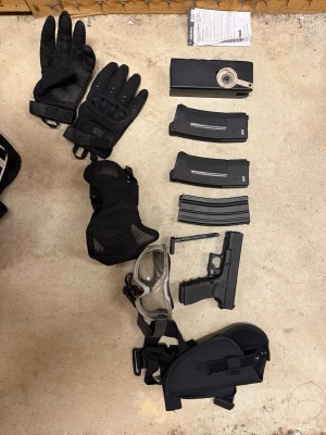 Airsoftutrustning med hjälm och magasin - Säljer ett komplett airsoftkit med svart hjälm, skyddsglasögon, taktiska handskar, knäskydd, ansiktsskydd, flera magasin och en airsoftpistol. Perfekt för dig som vill börja med airsoft eller behöver extra utrustning. Allt i svart och tåligt material. Märken och kvitton kan skickas