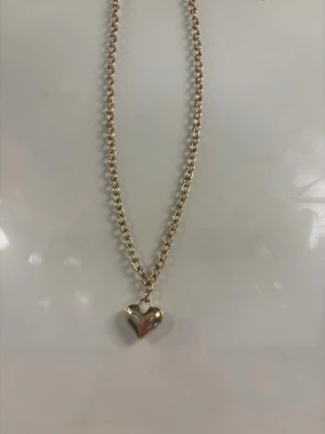 Guldigt halsband med hjärthänge - Snyggt halsband i guldfärgad metall med en kedja och ett hjärtformat hänge. Köpt från Gekås Ullared!❣️