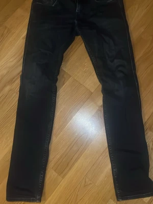 Mörkblåa jeans från Replay 28/32 - Säljer ett par svarta jeans från Replay med klassisk femficksdesign och raka ben. Jeansen har diskreta slitningar och kontrastsömmar. Materialet är mjukt och stretchigt för extra komfort. Perfekta för dig som gillar en stilren look. Pris kan diskuteras. Anbass slim fit
