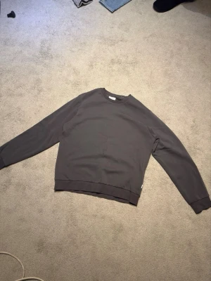 Mörkgrå sweatshirt med rund hals - En mörkgrå sweatshirt som passar S/M