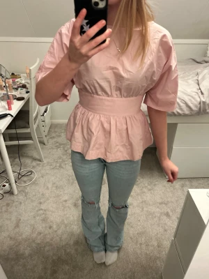 Ljusrosa topp - Jättesöt ljusrosa topp med volanger nedtill och rosett i ryggen. Använd någon enstaka gång💕 Tveka inte att skriva om du är intresserad eller vill ha fler bilder. Pris kan diskuteras❤️