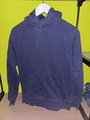 Mörkblå hoodie These Glory Days - Snygg mörkblå hoodie från These Glory Days i storlek S. Klassisk modell med huva och dragsko, ribbade muddar vid ärmslut och nederkant. Perfekt för en avslappnad och stilren look. Tillverkad i mjukt material för extra komfort.