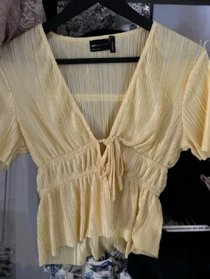 Gul topp från asos - (inte min bild) gul knyttop från asos som man knyter där fram.