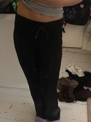 Svarta mjukisbyxor med dragsko - Säljer ett par svarta mjukisbyxor med dragsko i midjan och raka ben. Perfekta för chill dagar hemma eller när du vill vara bekväm. Tillverkade i mjukt material som känns skönt mot huden.