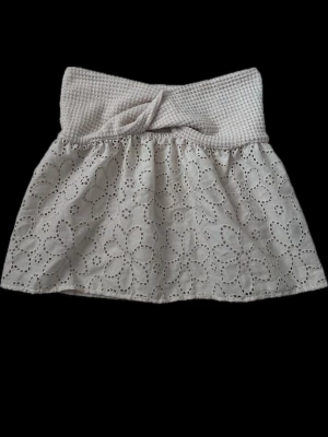  tubtopp med spets - Söt vit tubtopp med bred virkad kant upptill och broderade blommor i spets över hela toppen. Inga defekter. Perfekt till kjol eller jeans. Toppen är axelbandslös.