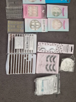 Skönhet - Massa olika saker. Örhängen, piercare, lösnaglar, lösfransar, sånt klister man sätter på naglarna så att lösnaglar fastnar, nagelklistermärken. Ni ser vad som är öppnat och använt men mycket kvar.