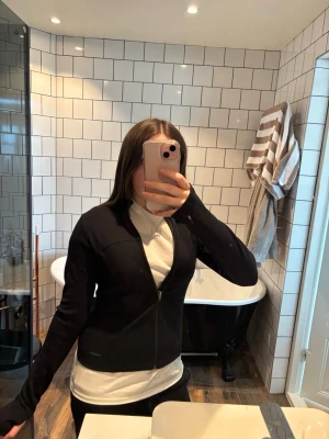 Svart zip tröja från Prozis - Svart zip hoodie från Prozis i stretchigt funktionsmaterial. Figurnära modell med dragkedja framtill och långa ärmar. Perfekt för träning eller chill. Köpt för 700kr och den är i ny skick. 