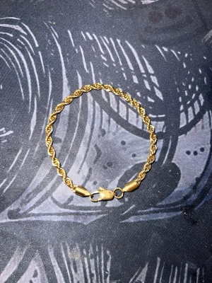 Guldarmband 18K tvinnad kedja - Snyggt armband i 18K guld med tvinnad kedja och karbinlås. Den klassiska designen gör att det passar perfekt till din stil och ger en lyxig känsla. Perfekt för dig som vill ha ett elegant smycke som sticker ut.