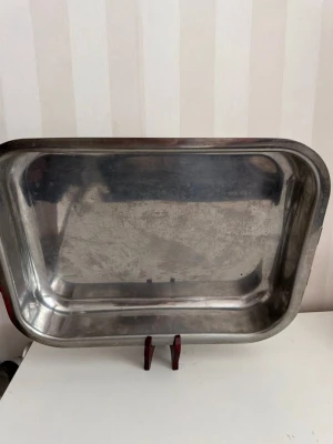 Rektangulär ugnsform i rostfritt stål - Stor rektangulär ugnsform i rostfritt stål med rundade hörn och praktiskt handtag på ena sidan. Perfekt för matlagning eller servering. Enkel att rengöra och tålig mot värme. Passar bra i köket för olika typer av rätter.