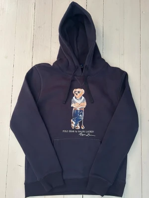 Ralph Lauren polo bear hoodie herr , storlek S  - Hej! Säljer denna riktigt schyssta polo bear hoodie från Ralph Lauren. Den är i storlek M men sitter en storlek litet och passar därför som en S. Den är endast använd någon enstaka gång och är därmed i ett nyskick. Original lappar och påse finns kvar och medföljer naturligtvis vid köp. Jag fraktar alltid snabbt! Mvh