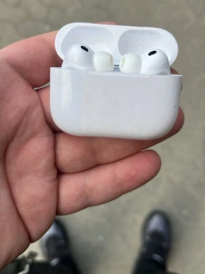 Apple AirPods Pro med laddningsetui - Säljer ett par vita Apple AirPods Pro med trådlöst laddningsetui. Hörlurarna har silikonproppar för bra passform och brusreducering. Smidig och kompakt design i blankt plastmaterial. Perfekta för musik, samtal och träning.