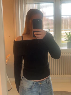 Svart off shoulder stickad tröja H&M - Säljer en svart stickad off shoulder-tröja från H&M. Tröjan har långa ärmar och en bred, nedvikt krage som ger en snygg axelbar look.