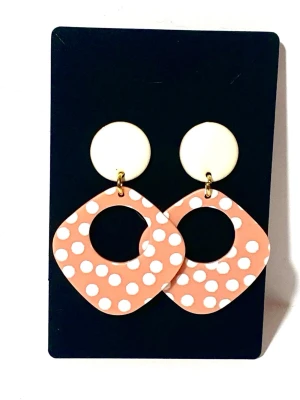 Coralrosa örhängen med vita prickar  - Örhängen med rhomb formad länk i akryl i coralrosa med vita prickar med runda platta enamel pläderade örhängen i metall.   Längd 5.5cm. Bredd/3.5cm.  