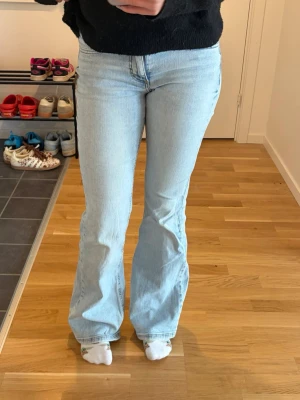 Ljusblå flare jeans - Säljer ett par ljusblå bootcut jeans med låg midja från Pull & Bear. Jeansen har en snygg utsvängd passform från knät och har 2 st knappar vid gylfen och är tillverkade i ett mjukt denimtyg. Hör av dig vid frågor eller intresse🥰