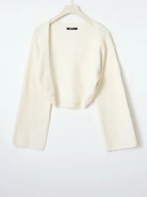 Vit stickad bolero från Gina Tricot - Säljer en vit stickad bolero från Gina Tricot. Modellen har vida ärmar och öppen front, perfekt att slänga över ett linne eller klänning. Materialet är mjukt och ribbstickat för en avslappnad look.