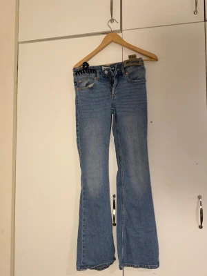 Blå bootcut jeans - Snygga ljusblå bootcut jeans från  med klassisk femficksdesign och hög midja (I length short).