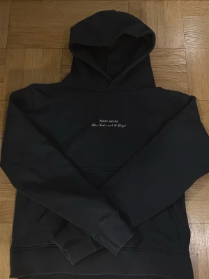 Svart hoodie Notre succès - Svart hoodie från Notre succès med tryck på bröstet där det står 'Notre succès - When Fashion meets the lifestyle'. Klassisk modell med huva och magficka. Perfekt för en chill och stilren look. Och en jätte stilig design på baksidan.