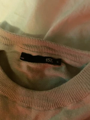 Beige tröja från 157, storlek S - En enkel och stilren beige tröja från 157 med rund halsringning och ribbade muddar vid ärmslut och nederkant. Perfekt basplagg att matcha med olika outfits. Materialet känns mjukt och bekvämt mot huden.