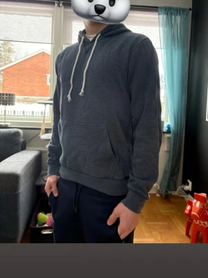 Blå Pier One hoodie strl s - Snygg och bekväm mörkgrå hoodie från Pier One i storlek S. Klassisk modell med huva, vita dragsnören och praktisk känguruficka framtill. Mjuk och skön kvalitet som gör den perfekt både för vardag, hemmamys eller en avslappnad streetwear-look.  Nopprig men fortfarande fin.  Normal passform som sitter snyggt utan att vara för tight – lätt att matcha med jeans, mjukisbyxor eller shorts.  I ganska bra skick, väl omhändertagen och fortfarande fräsch i färg och form.  ! OBS GANSKA NOPPRIG !