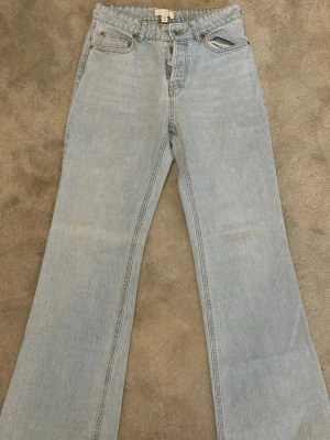 Ljusblåa bootcut jeans - Säljer ett par ljusblåa bootcut jeans med mid waist midja och klassisk femficksdesign. Jeansen har raka ben som blir vidare nedtill och stängs med knapp . Perfekta för en avslappnad och trendig look.